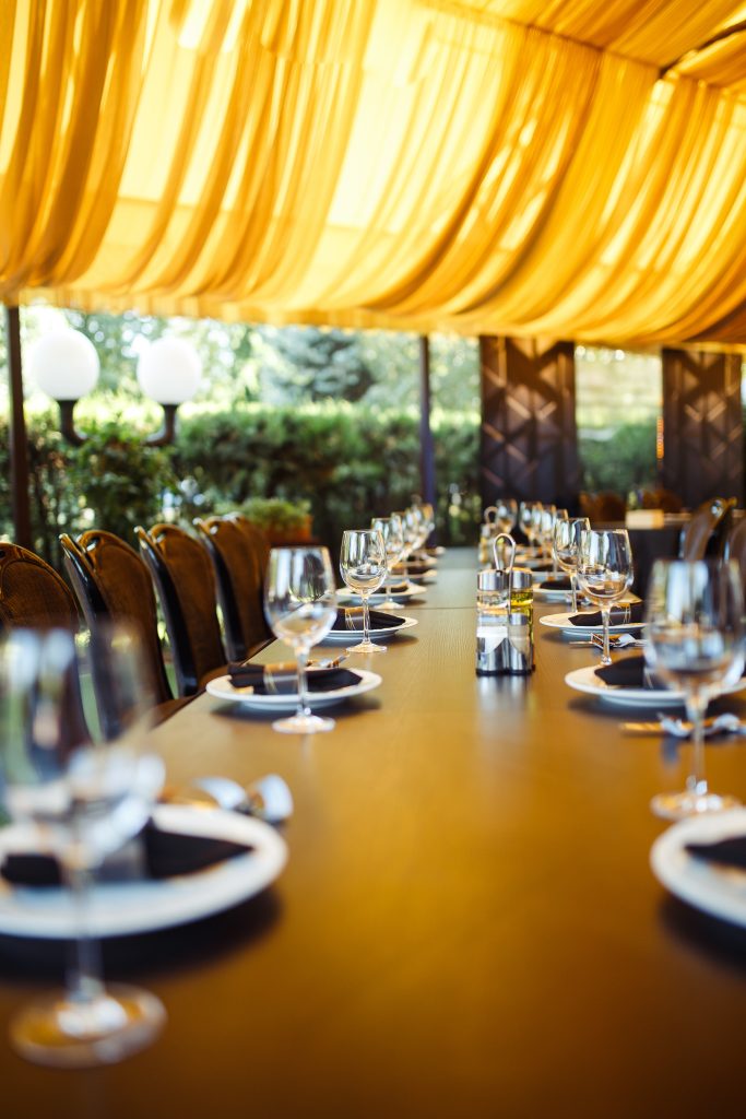 A beautifully arranged dinner table adorned with elegant yellow drapes, creating a warm and inviting atmosphere for a party.