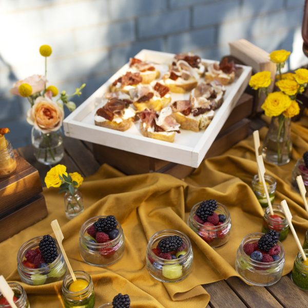 A table adorned with an array of fruits and various food items, set up for a festive gathering with party equipment.